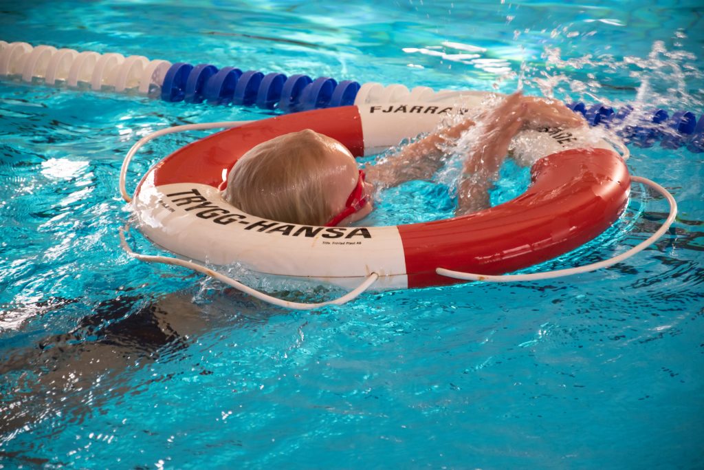 Ett barn övar på att använda livboj i vattnet.